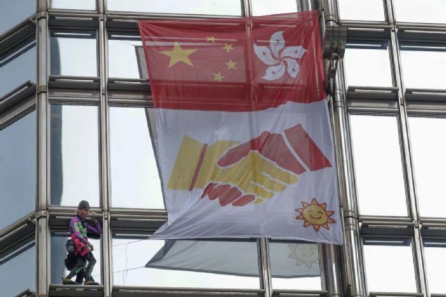 Fransız 'Örümcek Adam' Alain Robert barış çağrısıyla Hong Kong'da bir gökdelene tırmandı.