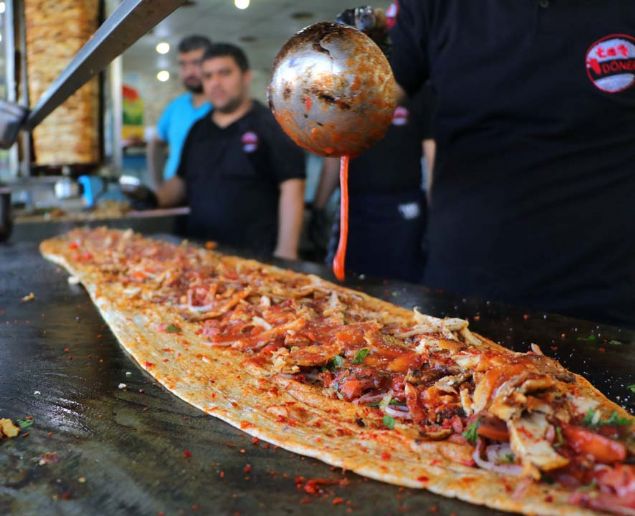 Adana'da sosyal medya sayesinde popüler hale gelen tavuk dönerci, 1 buçuk metrelik 'piton döner' ile farklı lezzet arayanların akınına uğruyor.