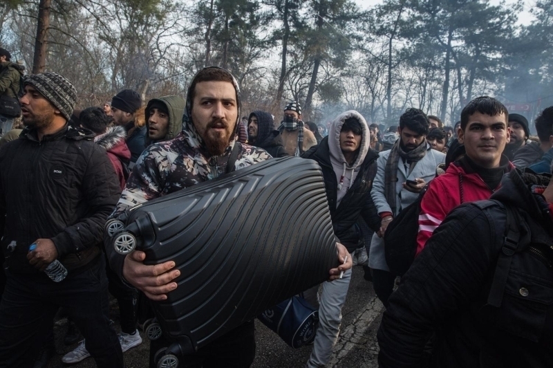 Tel �rg�leri a�arak kar�� tarafa ge�meye �al��an g��menler ise Yunan askerlerini ta�la kar��l�k veriyor. 