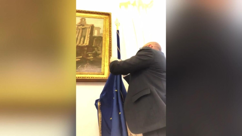 <p>Rampelli, odasında bulunan Avrupa Birliği bayrağını kaldırdı...</p>