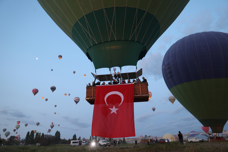 <p>Nevşehir'in Göreme beldesindeki kalkış alanında ekiplerce uçuş için hazırlanan sıcak hava balonlarının sepetlerine Türk bayrakları ve Atatürk posterleri asıldı.</p>