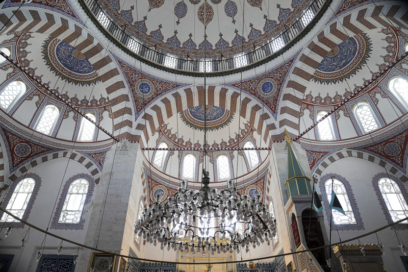 <p>Kanbaş, Sinan'ın, Edirne'deki Üç Şerefeli Cami ve Beşiktaş'taki Sinan Paşa Camisi'nin geliştirilmiş şekliyle Valide-i Atik Camisi'ni inşa ettiğini belirterek, 'Sadece bir cami değil, adeta bir külliye. Yani etrafında şifahanesinin, sıbyan mektebinin, darülkurranın, darülhadisin, ticarethanelerin, fakirlerin bir tas çorba alabilmek için sanki gitmek mecburiyetinde kaldıkları bir imarethanenin ve üniversite öğrencilerinin eğitim alabildiği bir medrese bulunuyor. Aslında ufak bir şehir.' dedi.</p>