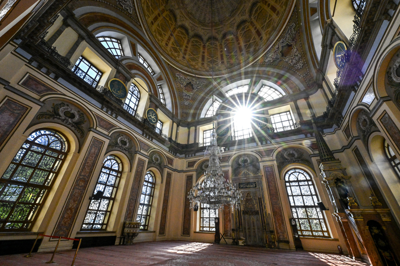 <p>As�l ad� 'Bezmialem Valide Sultan Camisi' olan yap�, Dolmabah�e Saray�'n�n saat kulesi y�n�ndeki kap�s�n�n tam kar��s�nda yer ald��� i�in yap�ld��� g�nden itibaren 'Dolmabah�e Camisi' ad�yla an�lmaya ba�land�.</p>