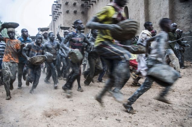 ocuk ve genlerin nehir yataklarndan toplad amurlar, kaplarla tanarak duvarlara svayacak ustalara gtrlyor.   