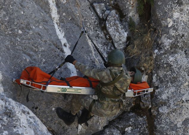 Komando kayas�n�n di�er yamac�nda ise yaralanan bir ki�inin kayal�k ve a�a�l�k alanda bulunmas� ve ta��nmas� g�revi ba�ar�yla icra edildi. Sarp kayalardan yaral�n�n yan�na inen komandolar, ilk m�dahalenin ard�ndan yaral� ki�iyi  sedye ald�. Ta��ma sisteminin kurulmas� ile bir komando e�li�inde sedye kayal�k alandan ��kart�ld�. Bir komandonun ise ayn� kayal�k alandan ��plak elle ger�ekle�tirdi�i t�rman�� takdir toplad�.   