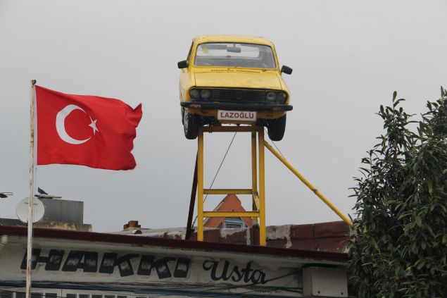 D�kkan�n�n �at�s�na direklerin �zerine 1987 model otomobili monte etti. Sanayinin bir�ok yerinden g�r�len otomobille m��terilerin ilgisini �ekmeyi ama�layan 'u�an araba' reklam� hedefine ula�t�. Yerden yakla��k 10 metre y�kseklikte olan otomobili g�renler �a�k�nl�klar�n� gizleyemiyor. Baz� vatanda�lar ise otomobille hat�ra foto�raf� �ektiriyor. 