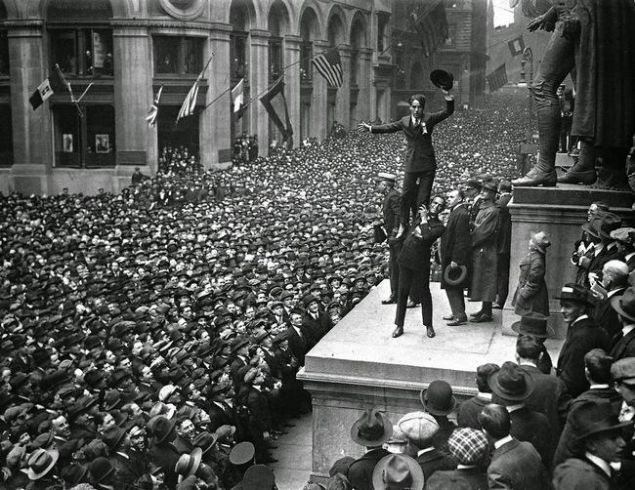                                                                  Douglas Fairbanks Jr. Charlie Chaplin'i �zg�rl�k Tahvillerini desteklemek i�in devasa kalabal�k �n�nde havaya kald�r�rken. Wall Street, New York, 1918.    
