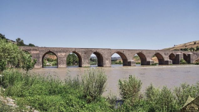                                                                 Dicle K�pr�s� - Diyarbak�r  <br><br>  Dicle K�pr�s� Diyarbak�r-Silvan yolunda ve Dicle nehri �zerinde do�u-bat� y�n�nde uzanan k�pr�, sivri kemerli on kemer g�z�nden olu�ur.    G�neybat� y�n�nde ve kara b�l�m�nde kalan ilk kemer aya��ndaki kitabe ku�a��n�n sol kanad�nda ve bir bazalt blo�una y�r�r vaziyette profilden i�lenmi� y�ksek kabartma aslan tasviri dikkat �ekmektedir.     Kit�be ku�a��nda k�pr� mimar�n�n ad� olarak �el-benn� Ukayl bin Sencer� yaz�l� oldu�u genel bir kabul g�rm��t�r.                                                         