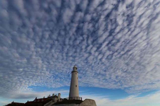 Whitley Koyu'ndaki St. Mary's Deniz Feneri'nin zerinde altokmls bulutlar, ngiltere.          