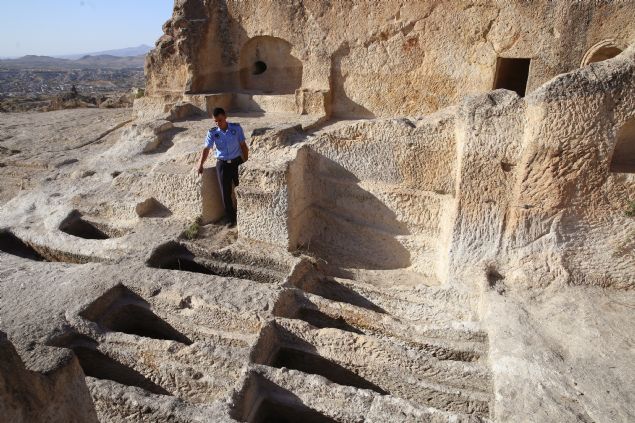 <p style='box-sizing: border-box; margin: 0px 0px 10px; padding: 0px; border: 0px; list-style-type: none; color: rgb(51, 51, 51); font-family: "Roboto Condensed"; font-size: 19px;'>  	Kapadokya'da kayadan oyma &ccedil;ok say�da farkl� nitelikte yap� bulundu�unu dile getiren Ate�, "Zindan Tepesi'nde herhangi bir kitabe bulunmuyor. Mimari yap�s�ndan yola &ccedil;�k�ld���nda 4'&uuml;nc&uuml; veya 5'inci y&uuml;zy�lda yap�ld��� d&uuml;�&uuml;n&uuml;l&uuml;yor. En ilgin&ccedil; k�sm� ise 18 kayadan oyma mezar var, biri yakla��k 3 metre boyunda. Burada ge&ccedil;mi�te definecilerin kaz�lar�nda ba�s�z iskeletlere ula��ld��� rivayet ediliyor. Dolay�s�yla giyotin ile infaz uygulamas�n�n yap�ld��� d&uuml;�&uuml;n&uuml;lmektedir." dedi.</p>  <div>  	&nbsp;</div>  