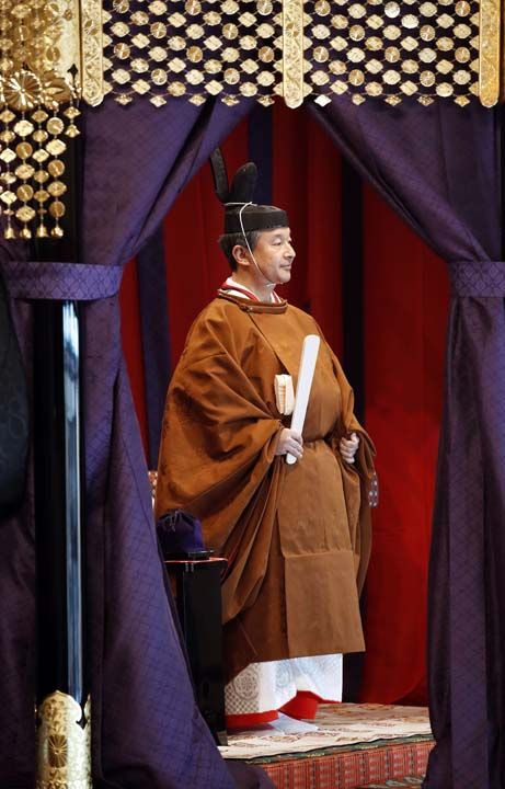 Naruhito, trende 'Korozen no go ho' ad verilen ve 9'uncu yzylda imparatorlarn giydii kahverengi tonlarnda kuakl geleneksel bir elbise giydi.   