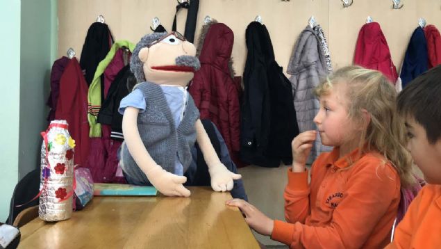 Dersleri anlat�rken 'Bakkal Amca' ismini verdi�i kuklay� kullanan, �zellikle matematik dersinde keman, gitar, ba�lama �al�p ney �fleyen Mahir ��retmen, kendi besteleriyle �ocuklara bilgi aktar�yor.  